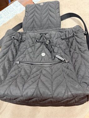 Kate Spade New York Ellie Large Flap Backpack in black quilted nylon..